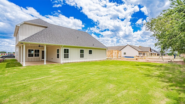 rear view of house with ceiling fan, a lawn, and a patio