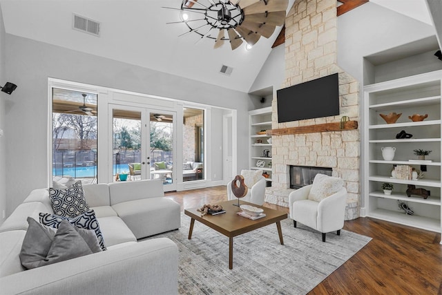 living room with hardwood / wood-style floors, built in features, high vaulted ceiling, a fireplace, and ceiling fan