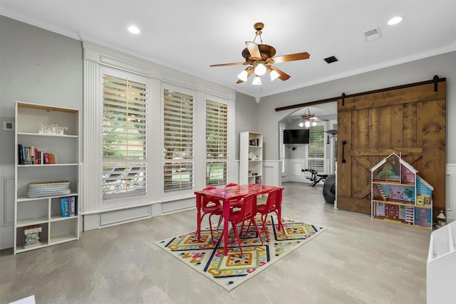 dining area featuring ornamental molding, a barn door, and ceiling fan