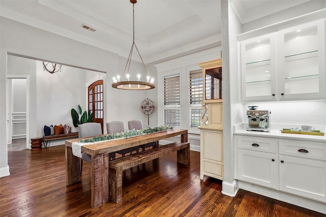 dining area with an inviting chandelier, crown molding, and dark wood-type flooring