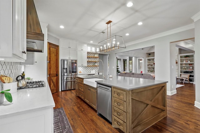 kitchen with white cabinetry, sink, hanging light fixtures, stainless steel appliances, and a center island with sink