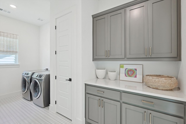 washroom featuring independent washer and dryer, light colored carpet, and cabinets