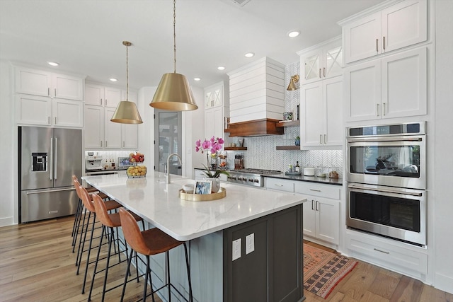 kitchen with hanging light fixtures, appliances with stainless steel finishes, and white cabinets