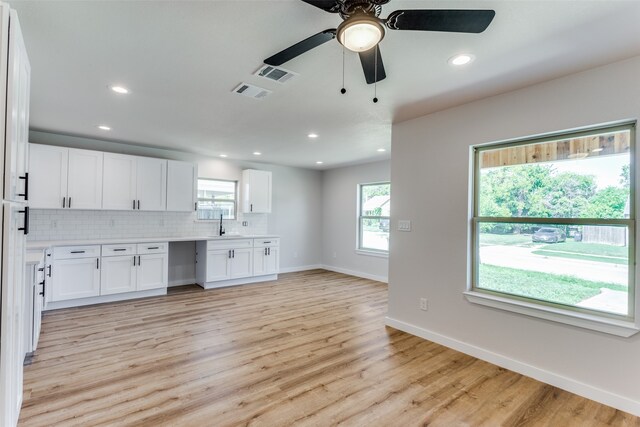 kitchen featuring ceiling fan, white cabinets, sink, tasteful backsplash, and light wood-type flooring