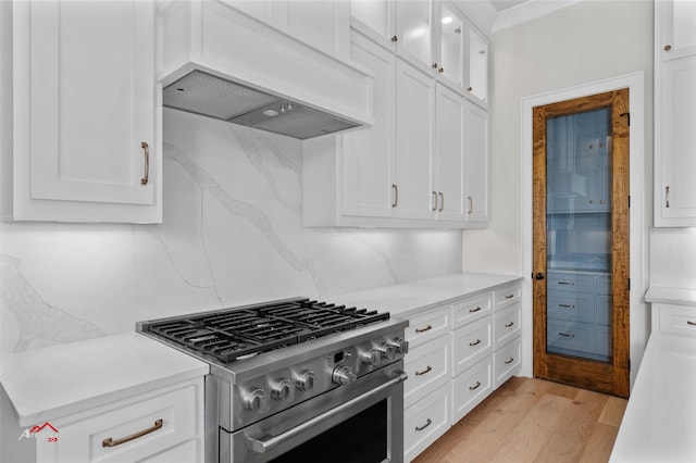 kitchen featuring white cabinets, stainless steel range, and premium range hood