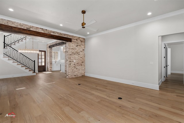 unfurnished living room featuring light hardwood / wood-style floors, ornamental molding, ceiling fan, and a barn door