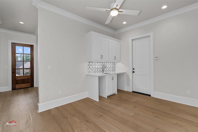 unfurnished office featuring light wood-type flooring, ceiling fan, crown molding, and sink