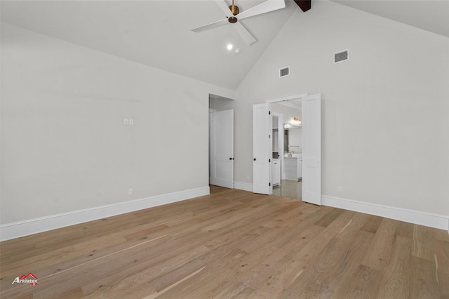 empty room featuring beam ceiling, light wood-type flooring, high vaulted ceiling, and ceiling fan