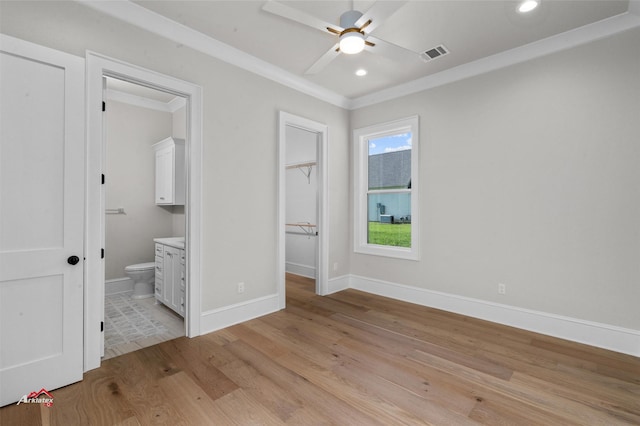 unfurnished bedroom with ensuite bathroom, ceiling fan, light wood-type flooring, a closet, and crown molding