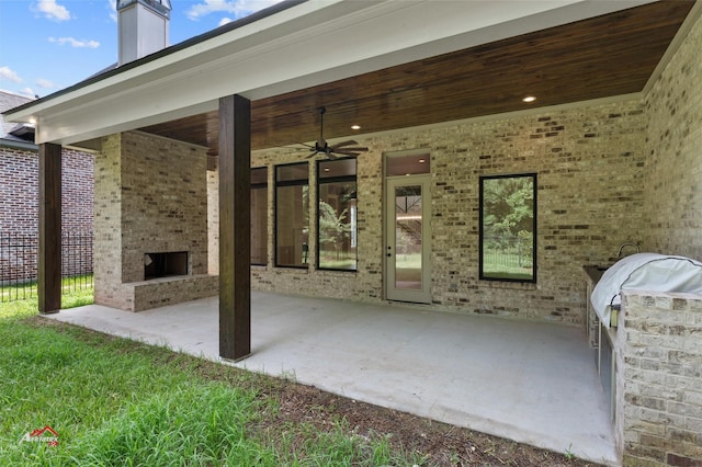 view of patio with ceiling fan and an outdoor stone fireplace