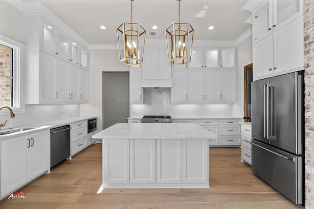 kitchen featuring white cabinetry, a center island, stainless steel appliances, and hanging light fixtures