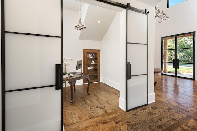 office area featuring a chandelier, a high ceiling, and wood finished floors