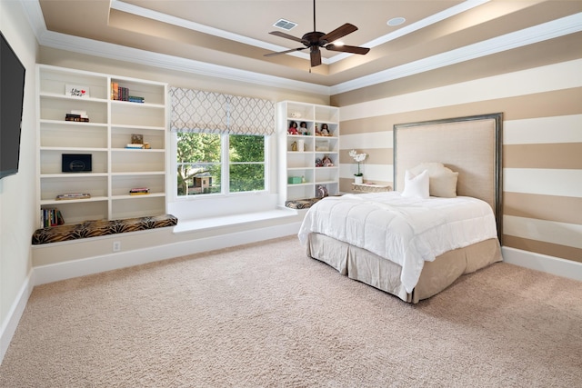 bedroom with carpet floors, crown molding, visible vents, and a tray ceiling