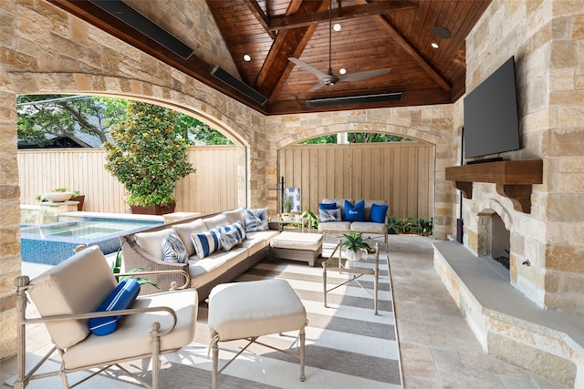 view of patio / terrace with an outdoor living space with a fireplace and ceiling fan