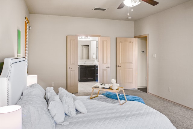 carpeted bedroom with ceiling fan and ensuite bath