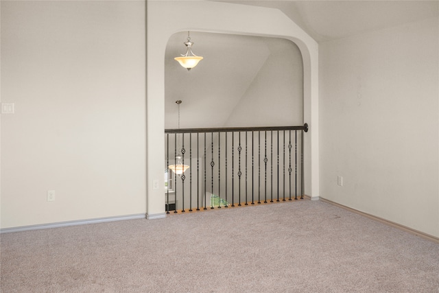 carpeted empty room featuring lofted ceiling