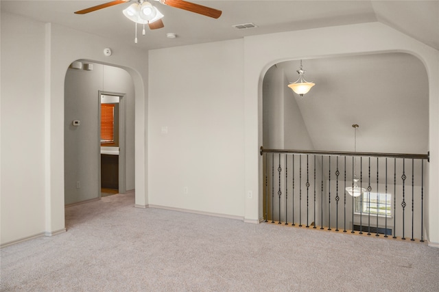 unfurnished room with ceiling fan, vaulted ceiling, and light colored carpet