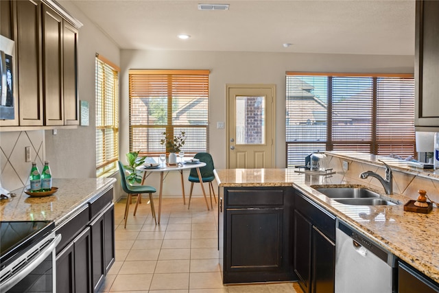 kitchen featuring a wealth of natural light, appliances with stainless steel finishes, sink, and light tile patterned floors