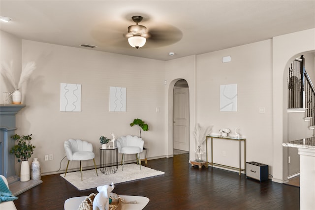 living area featuring ceiling fan and dark hardwood / wood-style floors