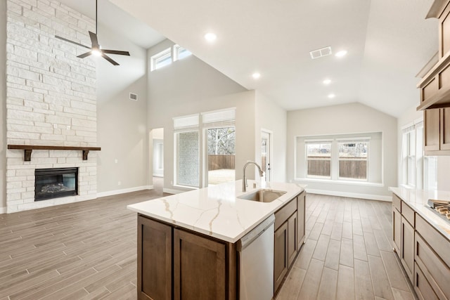 kitchen with an island with sink, plenty of natural light, sink, and stainless steel dishwasher