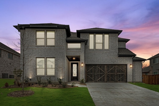 view of front of house featuring a yard, a garage, and central air condition unit