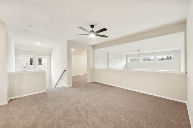 carpeted spare room featuring ceiling fan