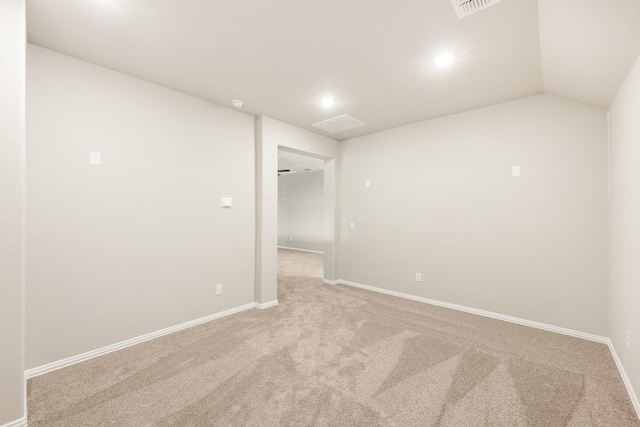 carpeted empty room featuring vaulted ceiling