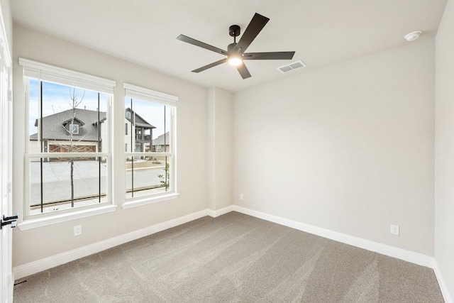 carpeted spare room featuring ceiling fan