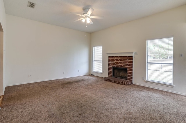 unfurnished living room featuring baseboards, visible vents, a ceiling fan, carpet floors, and a brick fireplace