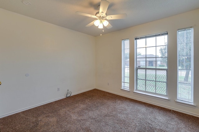 carpeted spare room featuring a ceiling fan, a textured ceiling, and baseboards