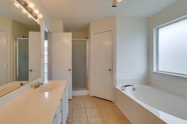 bathroom featuring a stall shower, a garden tub, vanity, and tile patterned floors