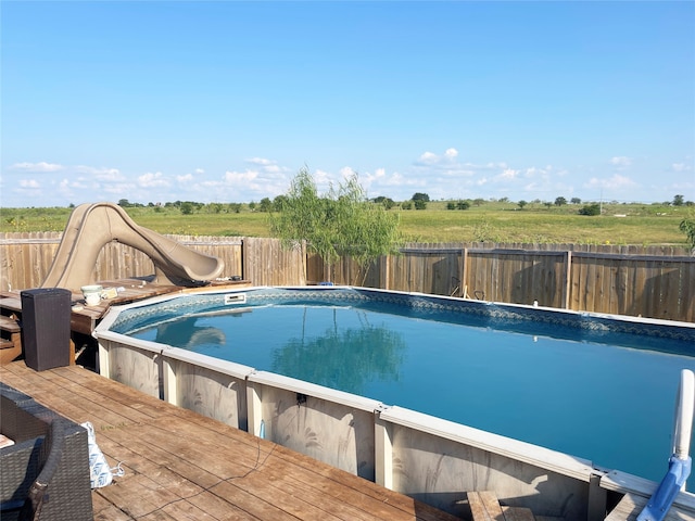 view of pool featuring a water slide and a deck