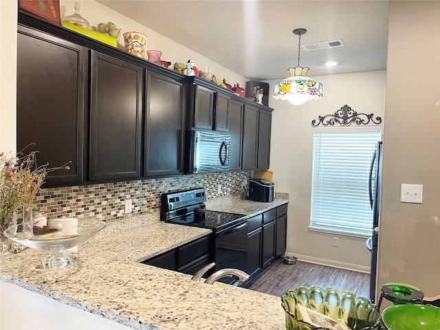 kitchen with light stone counters, black appliances, tasteful backsplash, and dark hardwood / wood-style floors