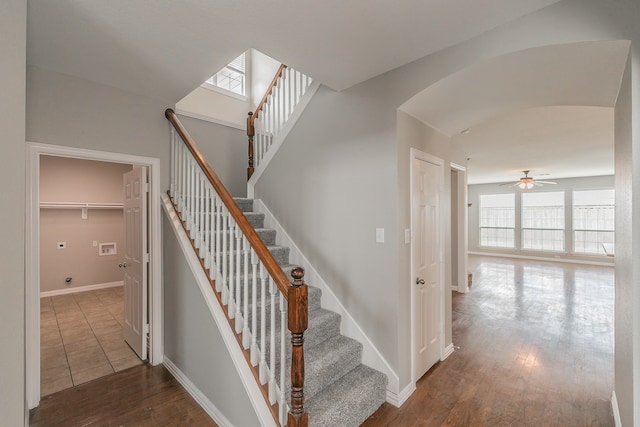 stairs featuring wood-type flooring and ceiling fan