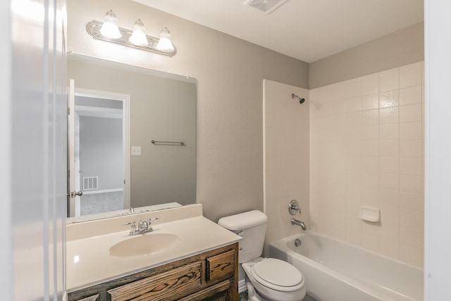 full bathroom with vanity, tiled shower / bath combo, and toilet