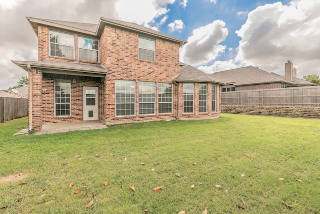 rear view of property featuring a patio and a lawn