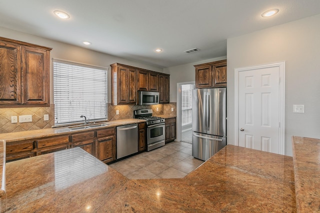 kitchen with light tile patterned flooring, stainless steel appliances, sink, and backsplash