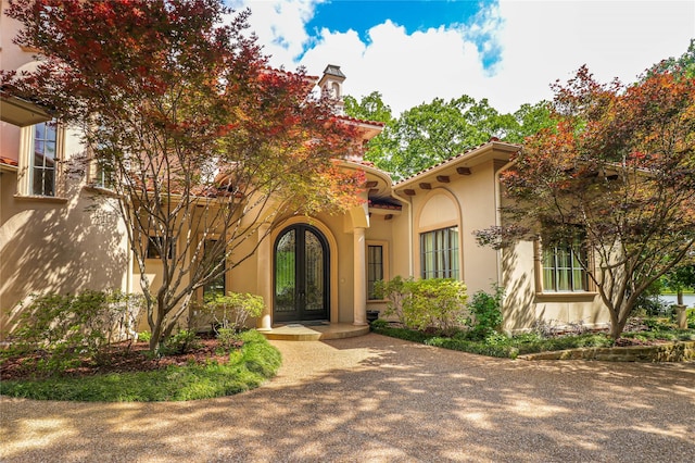 view of front facade featuring stucco siding, french doors, and a tile roof