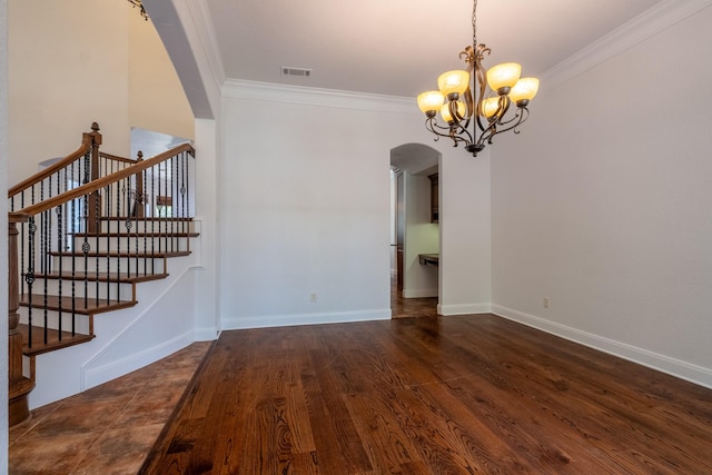 empty room with dark wood-type flooring, ornamental molding, and an inviting chandelier