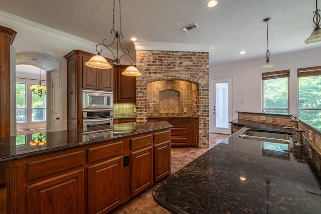 kitchen with decorative light fixtures, sink, backsplash, and stainless steel appliances