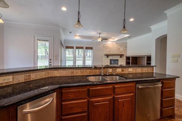 kitchen with sink, hanging light fixtures, stainless steel dishwasher, and a tray ceiling