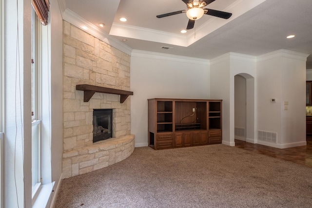 unfurnished living room with a fireplace, ornamental molding, a raised ceiling, and carpet flooring