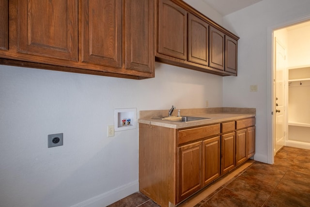 laundry room featuring dark tile patterned flooring, cabinets, sink, hookup for a washing machine, and hookup for an electric dryer