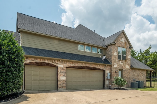 view of front of property with central AC unit and a garage