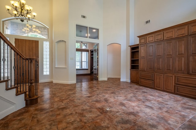 foyer entrance featuring an inviting chandelier and a towering ceiling