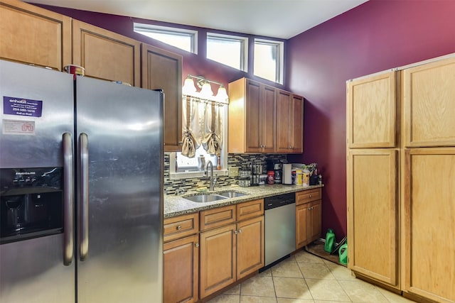 108 5th St, Whitney, TX 76692 - kitchen featuring stainless steel appliances, a sink, backsplash, light stone counters, and light tile patterned floors