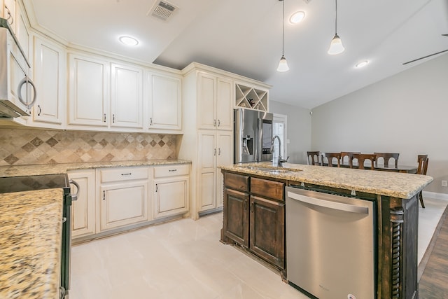 kitchen featuring stainless steel appliances, decorative light fixtures, decorative backsplash, sink, and light stone countertops