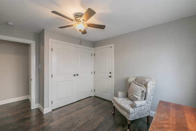 living area featuring ceiling fan and dark hardwood / wood-style flooring