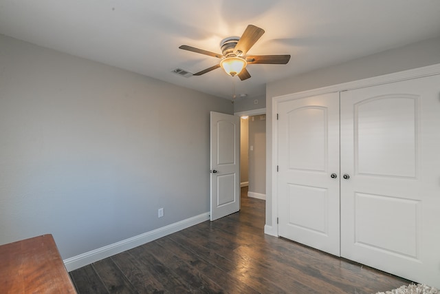 unfurnished bedroom featuring dark hardwood / wood-style flooring, a closet, and ceiling fan