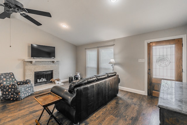 living room with a stone fireplace, ceiling fan, dark hardwood / wood-style flooring, and lofted ceiling